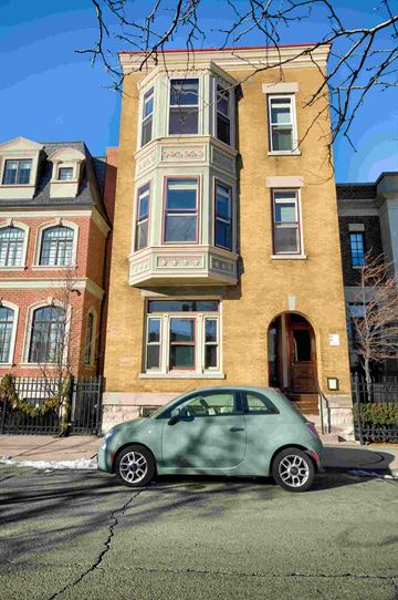 Chicago apartment for rent - a green car parked in front of a building