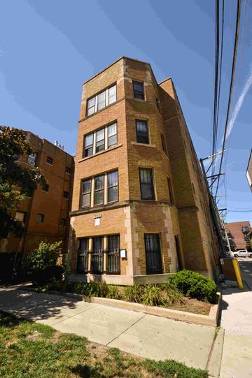 Chicago apartment for rent - a tall brick building with a sidewalk in front of it