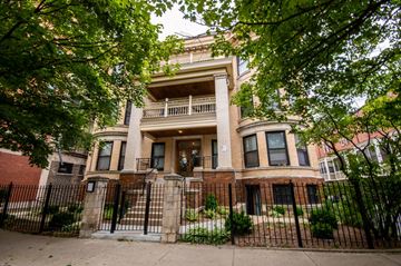 Chicago apartment for rent - an old brick house with a wrought iron fence in front of it