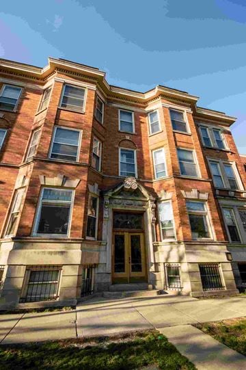 Chicago apartment for rent - a red brick building with a golden door and windows