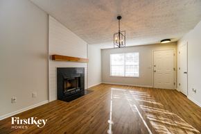 Grove City house for rent - A room with a fireplace and wooden floors.