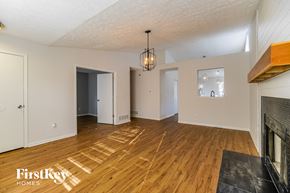 Grove City house for rent - A spacious living room with wooden floors and a fireplace.