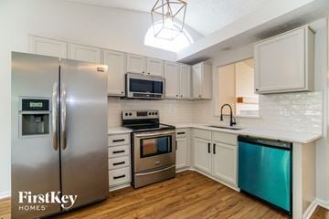 Grove City house for rent - A kitchen with a stainless steel refrigerator and a stove top oven.