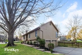 Kansas City house for rent - A beige house with a tree in front of it.