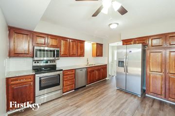 Kansas City house for rent - A kitchen with wooden cabinets and stainless steel appliances.