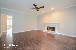Alabaster house for rent - A spacious room with a fireplace and a ceiling fan.