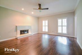 Alabaster house for rent - A spacious room with a fireplace and a ceiling fan.