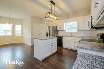Alabaster house for rent - A kitchen with white cabinets and a granite countertop.