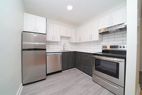 Winnipeg apartment for rent - an empty kitchen with stainless steel appliances and white cabinets
