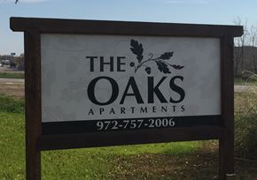 Kaufman apartment for rent - A sign for The Oaks Apartments with a phone number on it.