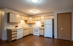 Wayland apartment for rent - A kitchen with white appliances and wooden cabinets.