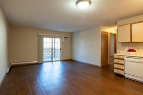 Wayland apartment for rent - A kitchen area with a white dishwasher and wooden cabinets.