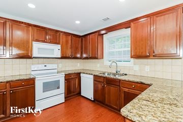 Snellville house for rent - A kitchen with wooden cabinets and a granite counter top.