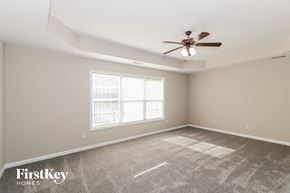 Snellville house for rent - A spacious room with a ceiling fan and a window.