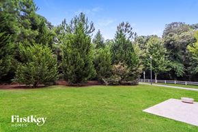 Snellville house for rent - A FirstKey Homes logo is displayed on a grassy area with trees in the background.