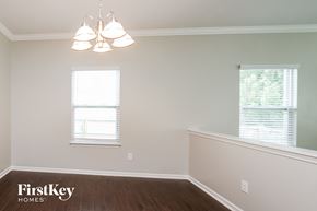 Statesville house for rent - a dining room with a wood floor and a chandelier and two windows