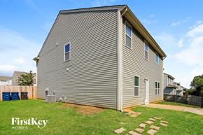 Statesville house for rent - side view of a house with gray siding and green grass