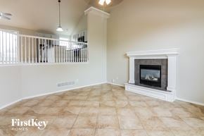 Raymore house for rent - an empty living room with a fireplace and a staircase