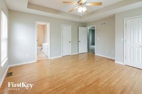 Raymore house for rent - an empty living room with wood floors and a ceiling fan
