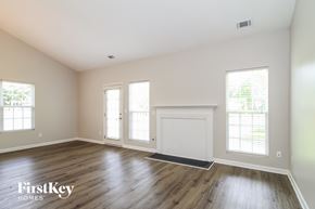Winston-Salem house for rent - an empty living room with wood floors and white walls