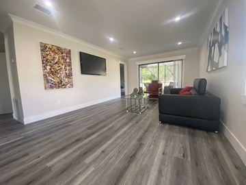 Port St. Lucie apartment for rent - A living room with a grey couch and a television on the wall.