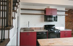 Detroit apartment for rent - a kitchen with red cabinets and a stove and a sink