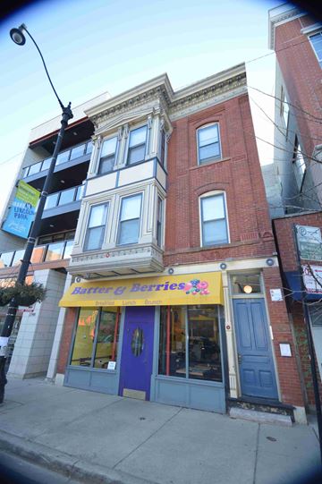 Chicago apartment for rent - a building with a blue door and a yellow sign on the front of it