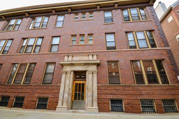 Chicago apartment for rent - a red brick building with a golden door and columns