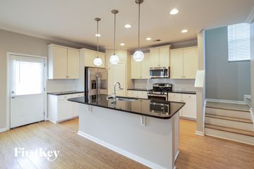 Johns Island house for rent - A kitchen with a black counter top and white cabinets.