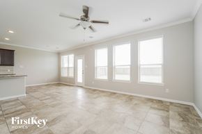 Richmond house for rent - an empty living room with a ceiling fan and a kitchen