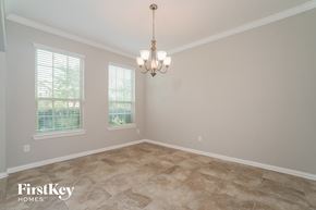 Richmond house for rent - a empty dining room with a chandelier and three windows