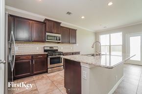 Richmond house for rent - a kitchen with a marble counter top and wooden cabinets