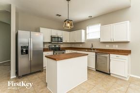 Royse City house for rent - a large kitchen with stainless steel appliances and white cabinets