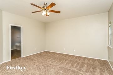 Royse City house for rent - the spacious living room with ceiling fan and carpet
