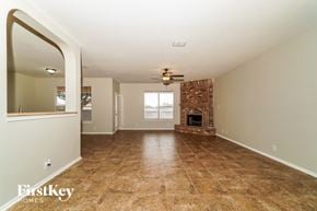 Cibolo house for rent - the living room with fireplace and tile flooring and a ceiling fan