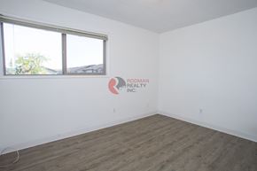 Longview apartment for rent - A room with a large window and a logo for Rodman Realty Inc. on the wall.