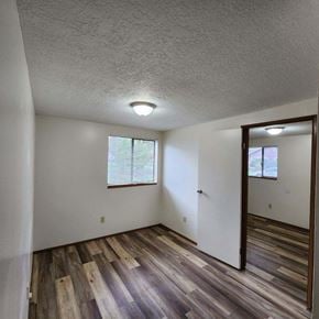 Longview apartment for rent - A room with wooden floors and a window with blinds.