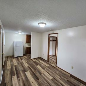 Longview apartment for rent - A room with wooden flooring and a white refrigerator.