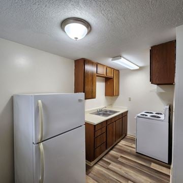 Longview apartment for rent - A small kitchen with a white refrigerator and a white stove.