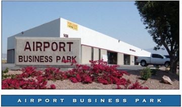 Orange apartment for rent - A white building with a sign that says Airport Business Park.