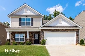 Whitsett house for rent - a home with a white garage door and a brick house