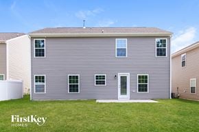 Whitsett house for rent - a gray house with white siding and green grass