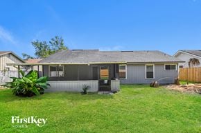 Jacksonville house for rent - a small gray house with a grass yard and a fence