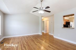 Durham house for rent - the living room and dining room with hardwood flooring and a ceiling fan