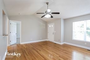Durham house for rent - a living room with wood floors and a ceiling fan