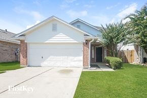 Cypress house for rent - a white house with a white garage door and a lawn