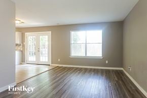 Cypress house for rent - an empty living room with wood floors and a window