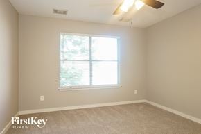 Cypress house for rent - a bedroom with a large window and a carpeted floor