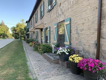 Elora apartment for rent - A row of flower pots line the sidewalk in front of a building.