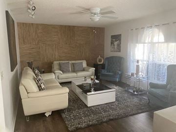 Sanford house for rent - A living room with a white sofa and a wooden wall.